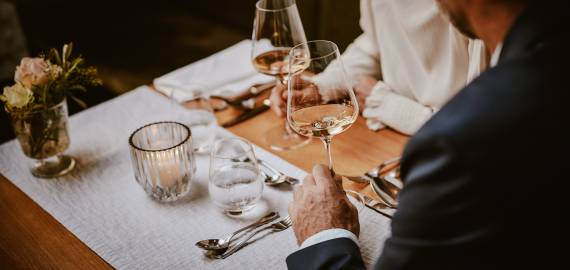 Mann schwenkt Weißwein in Hotelrestaurant