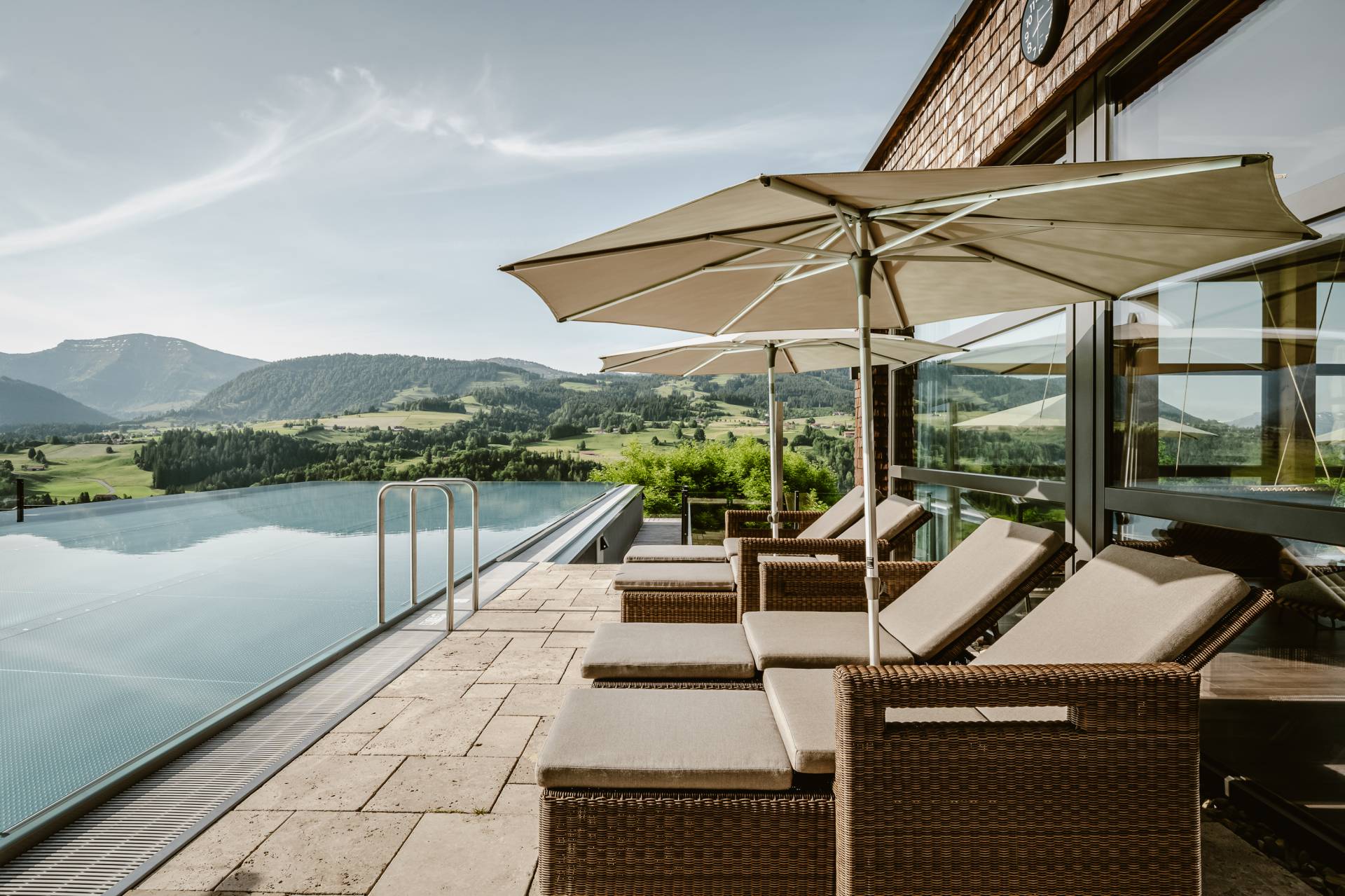 Außenansicht Infinitypool des Wellnesshotel Bergkristall im Allgäu mit Sonnenliegen