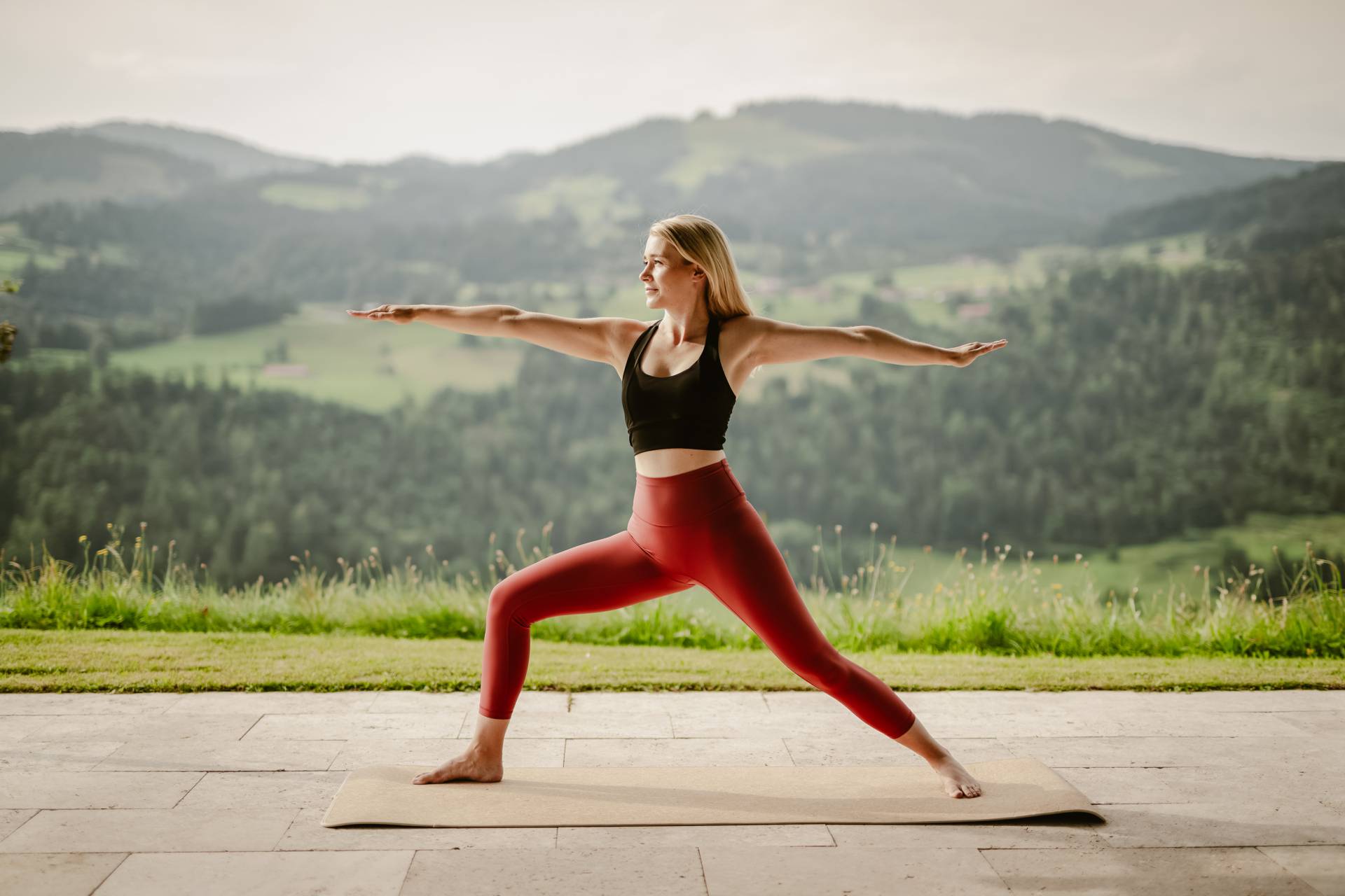 Frau praktiziert Yoga auf dem Yoga-Plateau des Wellnesshotels Bergkristall