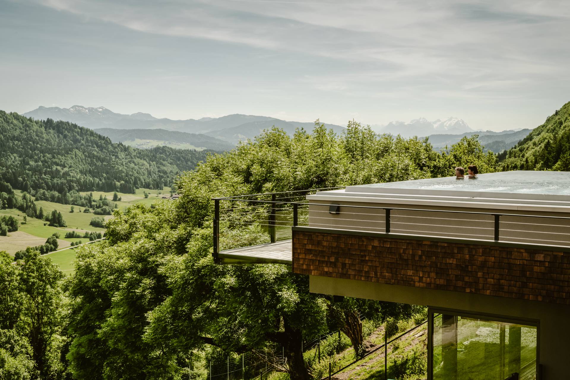 Paar im Infinitypool mit Blick in die Schweizer Berge