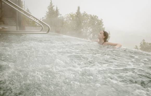 Frau im Panorama-Whirlpool mit geschlossenen Augen