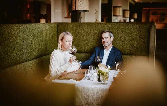 Paar trinkt Rotwein und genießt den Abend am Tisch