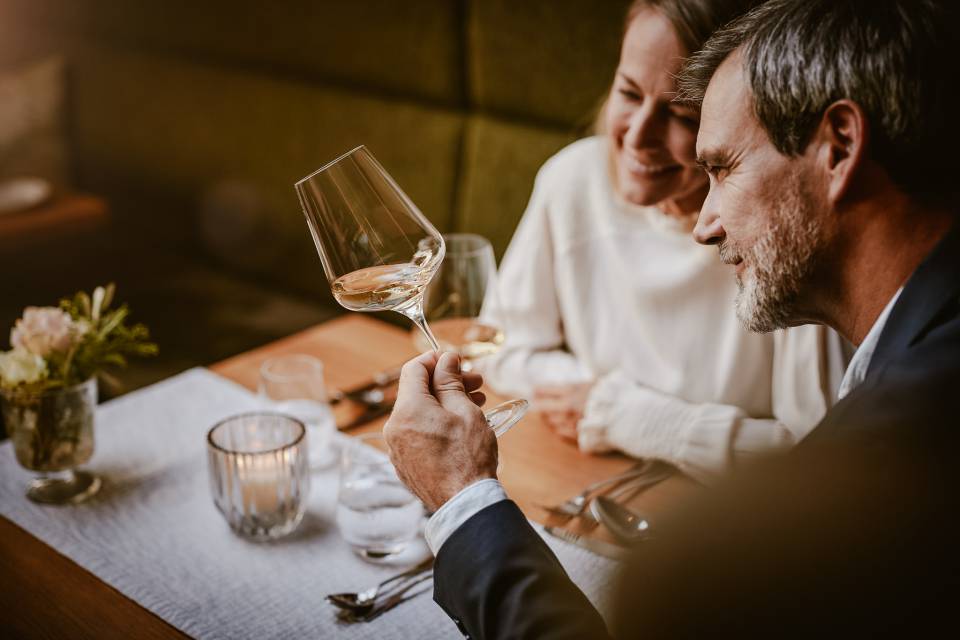 Paar trinkt Rotwein und genießt den Abend am Tisch