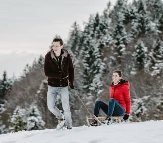 Paar beim Schlittenfahren im Allgäu