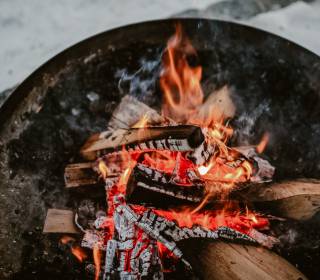 Schale mit Brennholz und Feuer