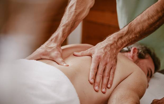 Mann bekommt kräftigende Massage