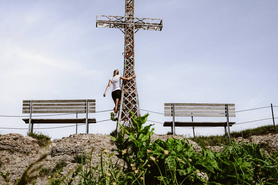 Frau an Gipfelkreuz des Hochgrats im Allgäu