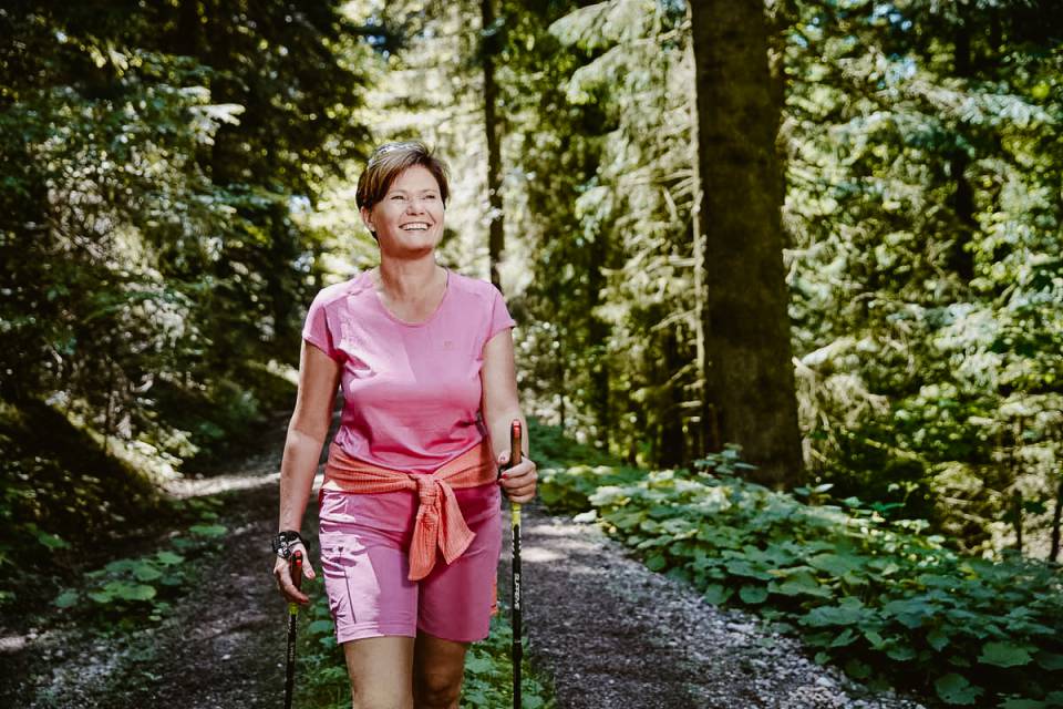 Frau beim Nordic Walking im Wald
