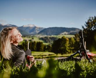 Frau mit E-Bike in Wiese