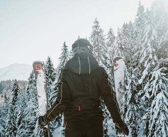 Frau mit Ski genießt Ausblick