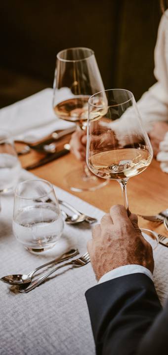 Mann schwenkt Weißwein in Hotelrestaurant