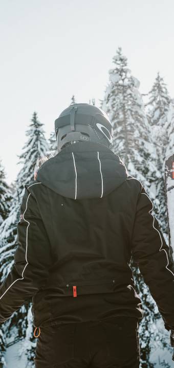 Frau mit Ski genießt Ausblick