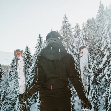 Frau mit Ski genießt Ausblick