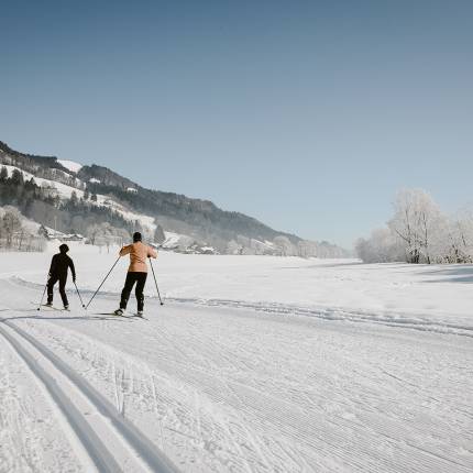 Paar geht Langlaufen in Winterlandschaft