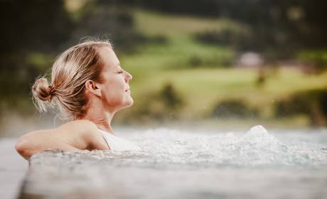 Frau sitzt in Infinitypool des Wellnesshotels Bergkristall