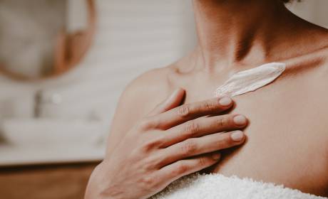 Frau hat Creme auf dem Dekoltée im SPA im Wellnessresort Bergkristall