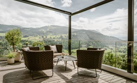 Gemütliche Sitzmöbel auf Terrasse mit Blick auf die Alpen