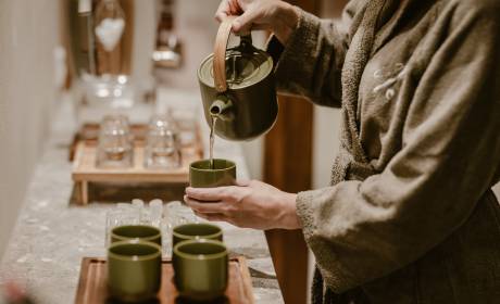 Frau  im Bademantel schenkt Tee ein