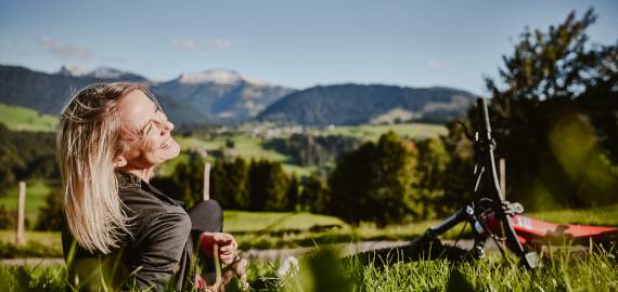 Frau mit E-Bike in Wiese