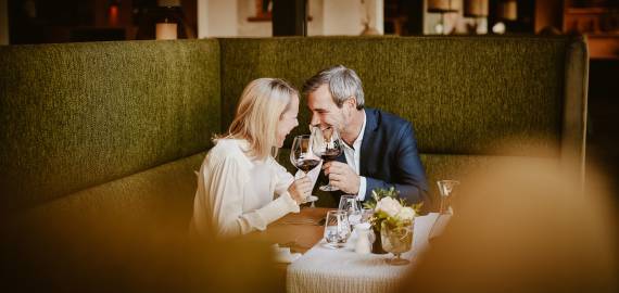 Couple clinks glasses of red wine