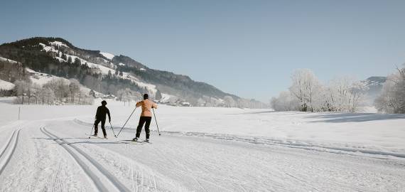 Paar geht Langlaufen in Winterlandschaft