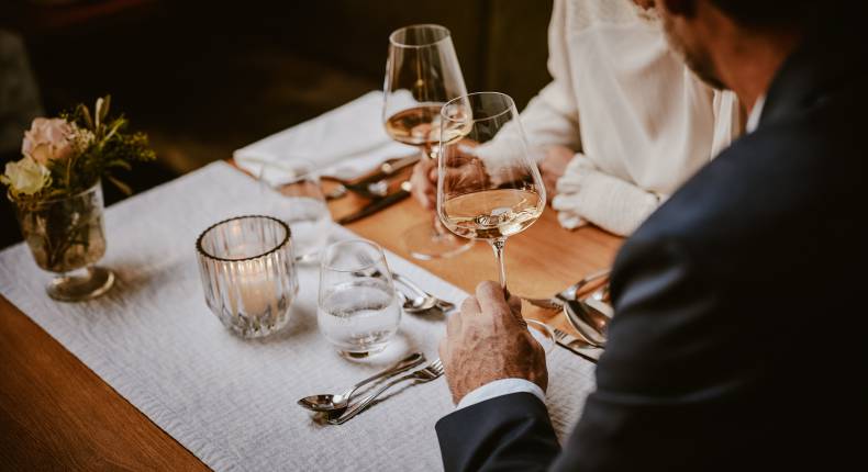 Mann schwenkt Weißwein in Hotelrestaurant