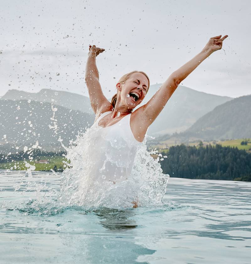 Frau springt freudig aus Pool