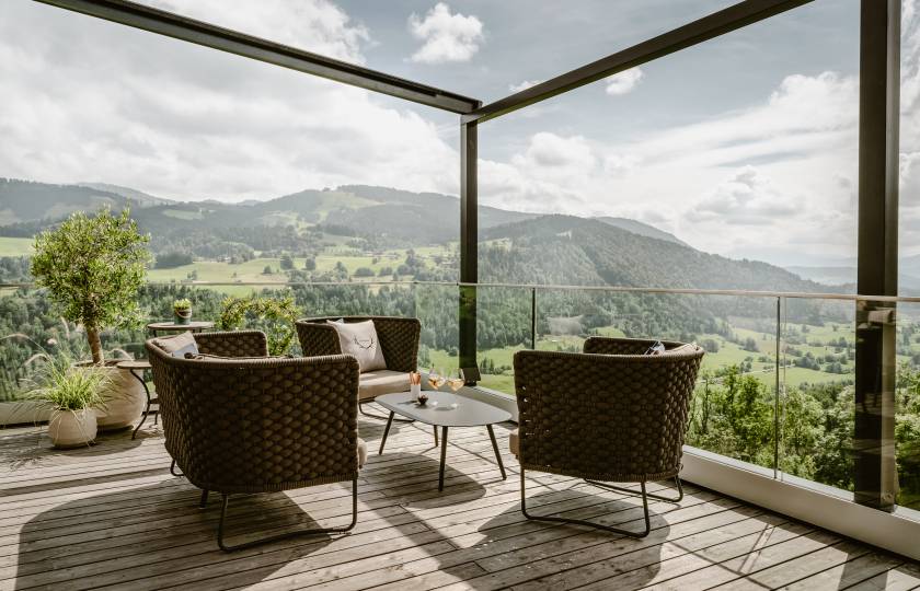 Gemütliche Sitzmöbel auf Terrasse mit Blick auf die Alpen