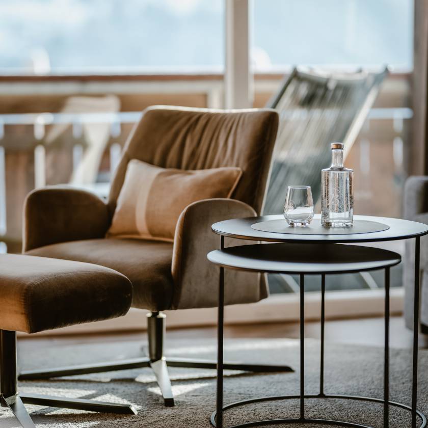 Sessel neben Beistelltisch mit Wasserkaraffe und Glas im Studio Paradies